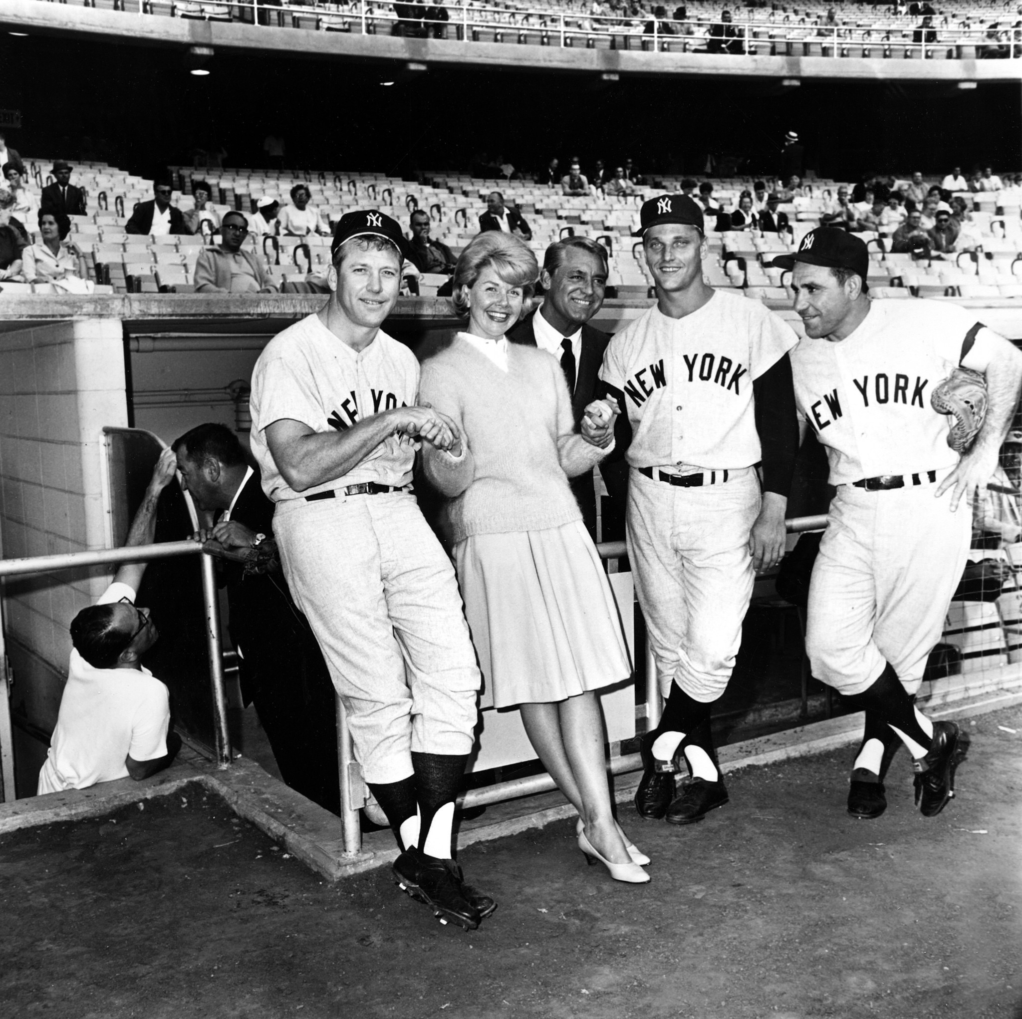 Actress Doris Day and actor Cary Grant stand in the dugout with New York Yankees players, from left, Mickey Mantle, Roger Maris and Yogi Berra, before the Yankees-Angels game on July 12, 1962, in Los Angeles. The players appeared in the movie 
