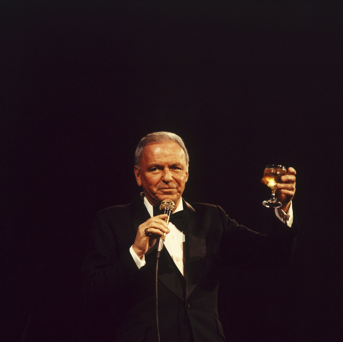 Raise a glass to Frank Sinatra! Even as he aged, Sinatra still enjoyed performing onstage. He is pictured here in 1975 toasting the audience during one of his shows in the UK.