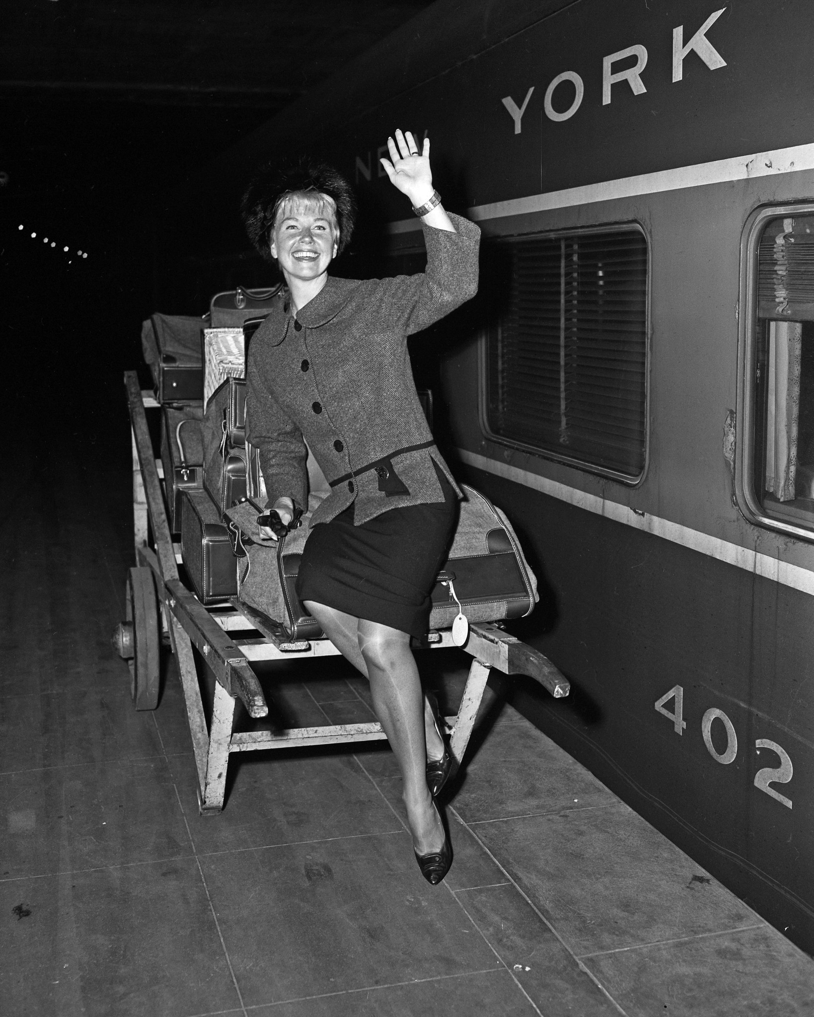 Cinema lovely Doris Day takes a ride on the baggage wagon at arrival on Oct. 2, 1960, at Grand Central Terminal. Day is in New York with her husband, producer Martin Melcher, for the world premiere of her latest film, 