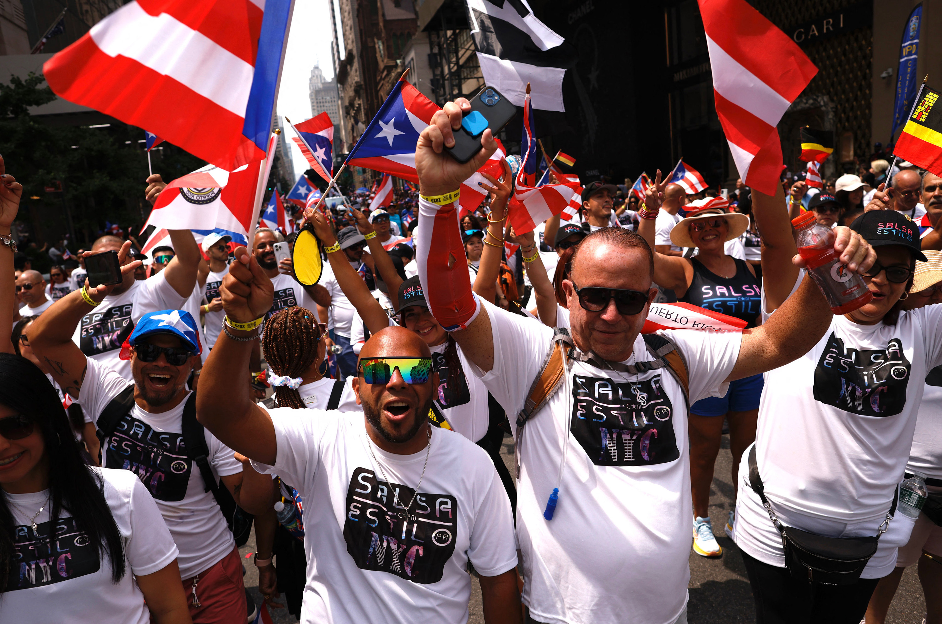 Participants hold flags as they march in the 66th annual National Puerto Rican Day Parade in New York City on June 11, 2023.