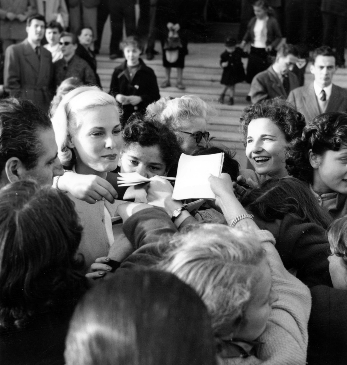 Grace Kelly, the stunning Hollywood star, style icon and future Princess of Monaco, signs autographs for her adoring fans at the Cannes Film Festival on April 8, 1953.